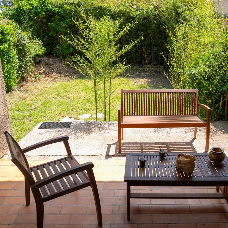 deux bancs et une table et un banc et une table et des chaises dans l'établissement maison climatisée fibrée 2 chambres à 9 min à pieds d'une grande plage, à Venzolasca