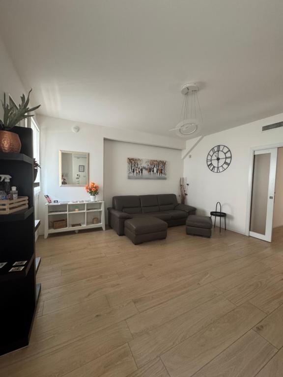 a living room with a couch and a clock on the wall at DB Apartments - Dabasso in Mestre