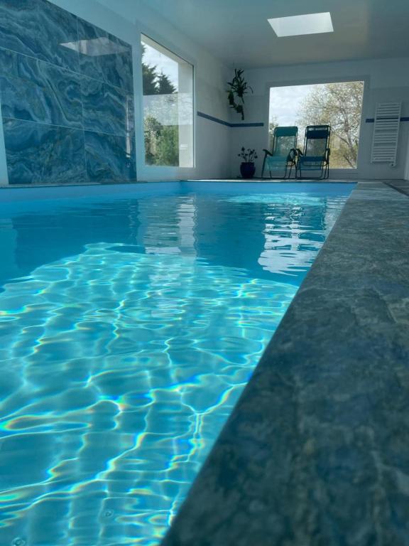 - une piscine à débordement avec eau bleue dans une maison dans l'établissement Beach at 300 m, swimming pool 29 Celsuis, 5 bedrooms, 4 bathrooms, quiet, à Bénodet
