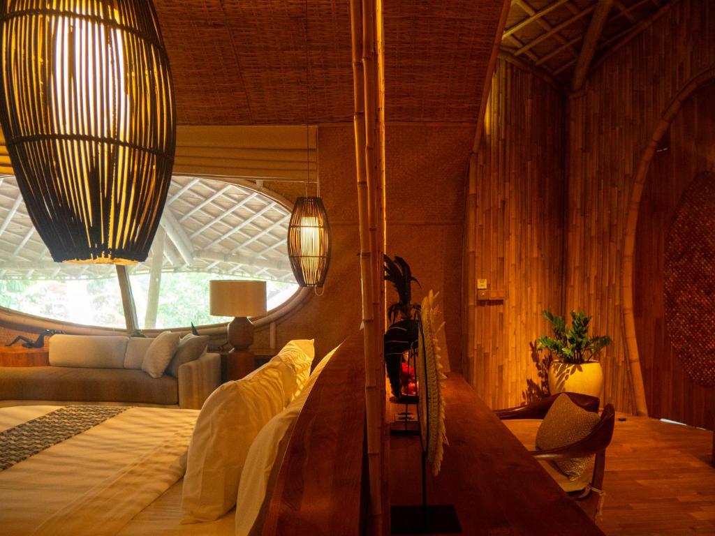 una camera da letto con un grande letto con una grande finestra di Ulaman Eco Luxury Resort a Tabanan