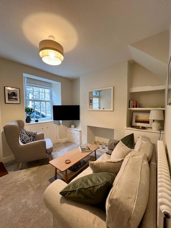 a living room with a couch and a table at Cosy Cottage Kendal in Kendal