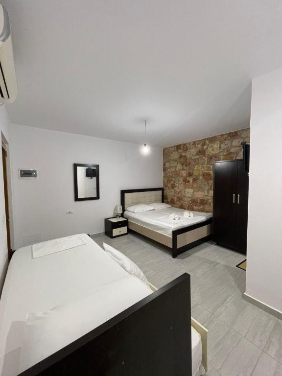 a bedroom with two beds and a tv in it at Grand Seaview Apartments in Ksamil