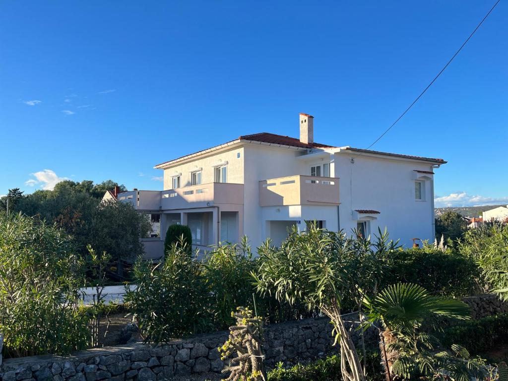 a white house with an arrow on it at Apartment Vitezic in Punat