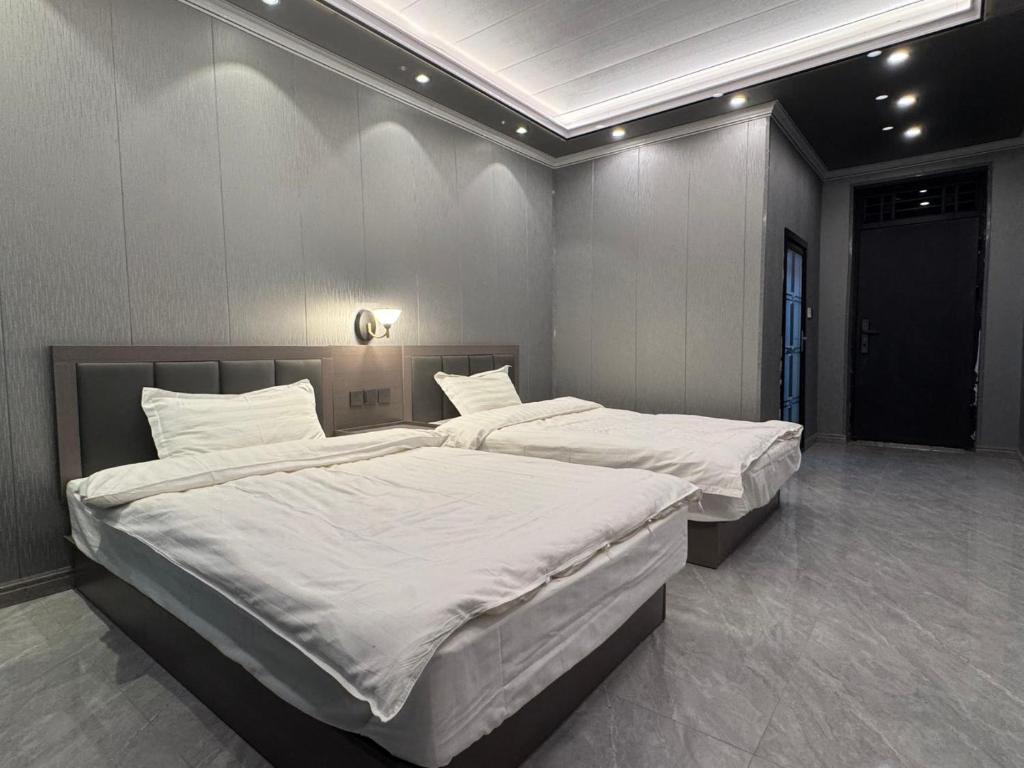Dos camas individuales en una habitación con en Tajiro Homestay, en Taxkorgan