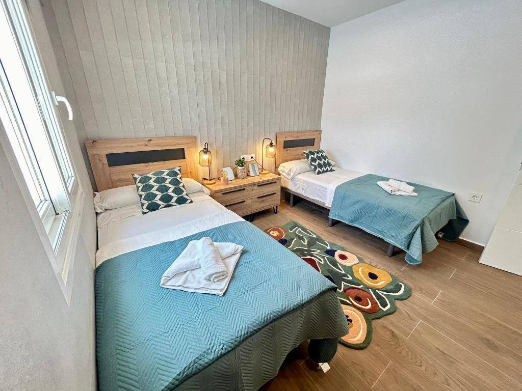 Una habitación de hotel con dos camas y una ventana. en Chalet Empul Los Pinares, en Chiclana de la Frontera