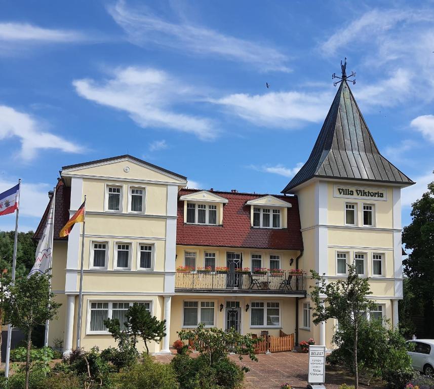 a large white building with a gray roof at Villa Viktoria Whg 20 - "Ostseeloft" in Kölpinsee