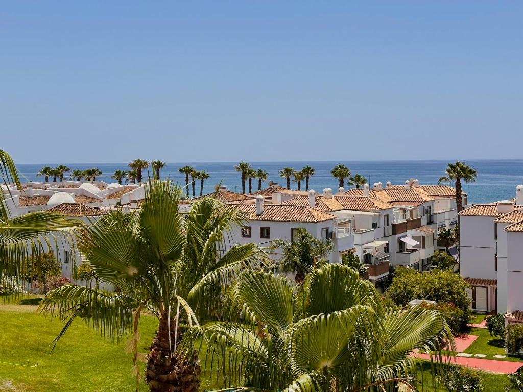 una vista di una città con palme e l'oceano di Vistamar Laguna Beach a Torrox Costa