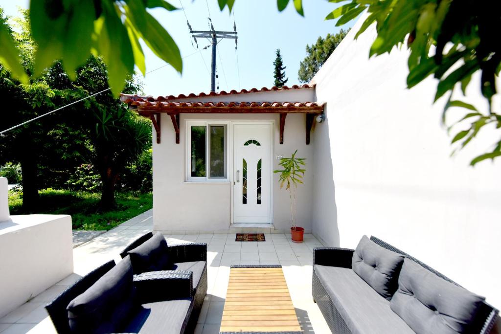 a white patio with couches and a white door at Liri family paradise Danis house in Ixia