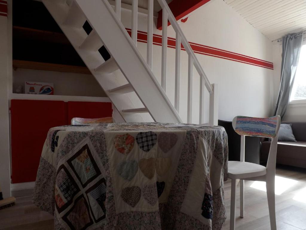 une pièce avec une table et un escalier blanc dans l'établissement Studio proche forêt, à Jouy-en-Josas