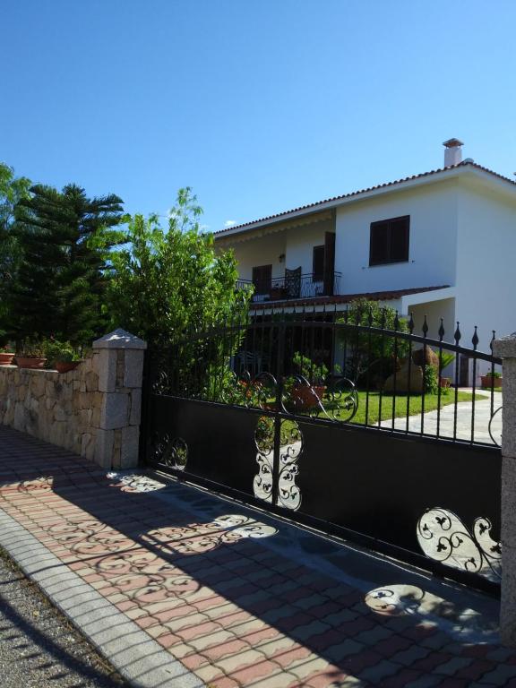 a black fence in front of a white house at Casa Su Lizzu in Tanaunella