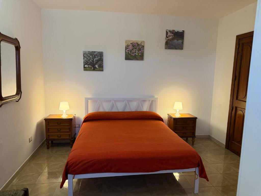 Un dormitorio con una cama con dos mesitas de noche y dos lámparas. en Casa Pianalto, en Tricase