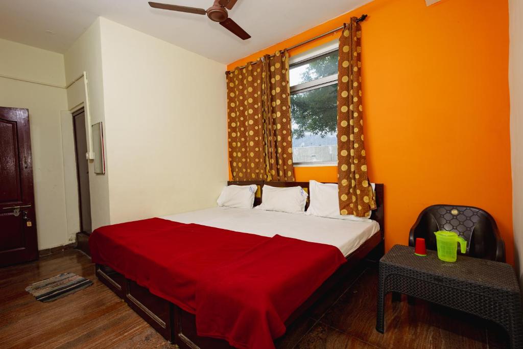 a bedroom with a bed with an orange wall at Pvt Residency in Palani