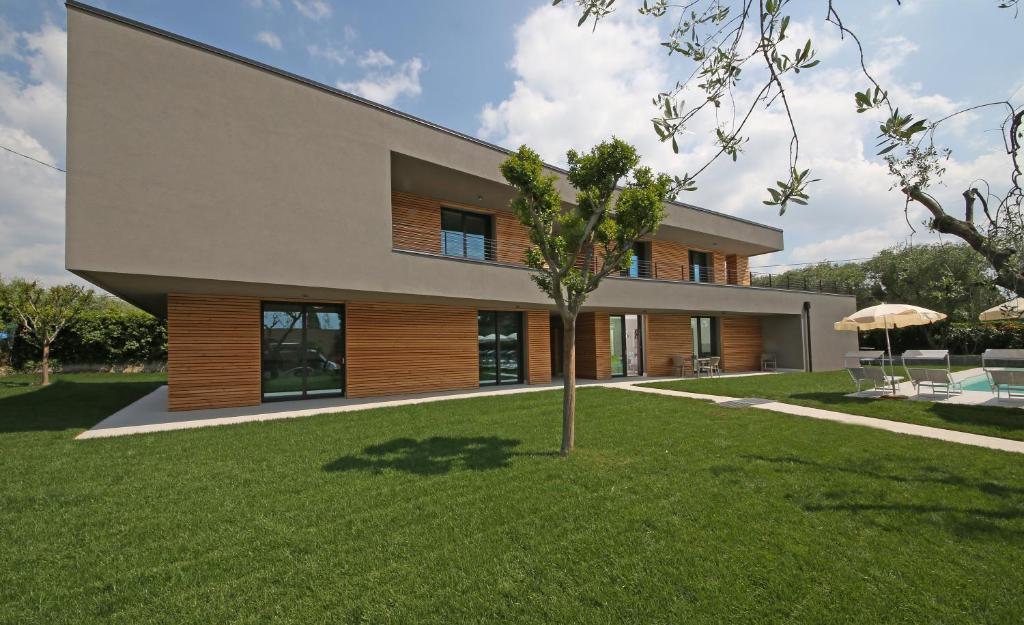 dom z drzewem przed nim w obiekcie Villa T14 w mieście Bardolino