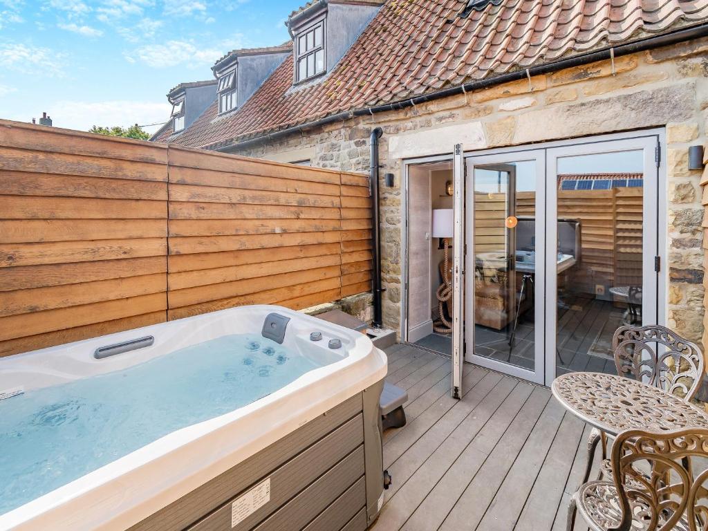 ein Whirlpool auf der Terrasse eines Hauses in der Unterkunft The Drunken Carpenter's Cottage in Sneaton