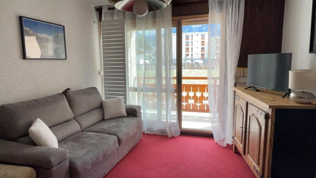 un salon avec un canapé et une télévision dans l'établissement Appartement aux pieds des pistes, à Les Deux Alpes