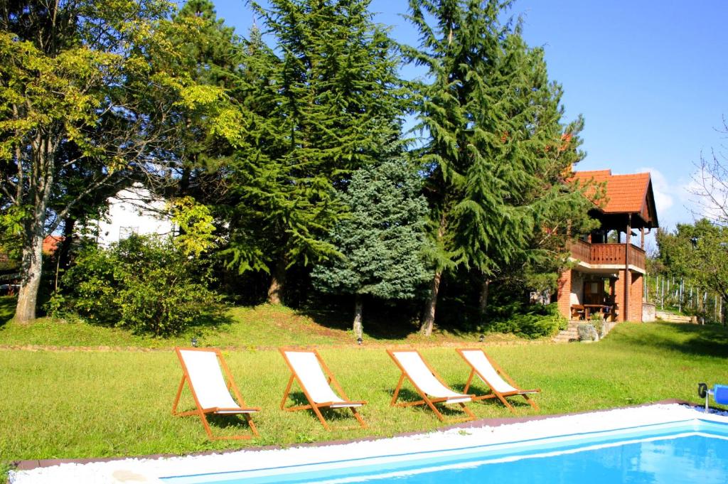 a group of lounge chairs next to a swimming pool at Il-Veduta: Country-estate in Oroslavje