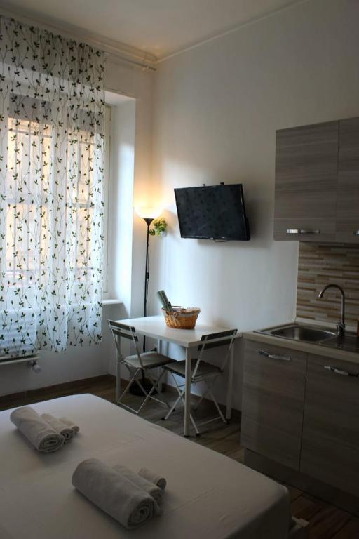 a kitchen with a table with chairs and a sink at cosycasa & free bike in Turin