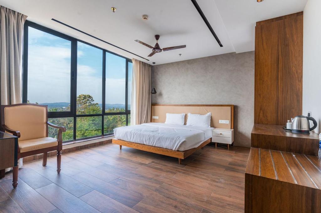 Un dormitorio con una cama y grandes ventanales. en Royal Holidays & Stays, en Pattāmbi