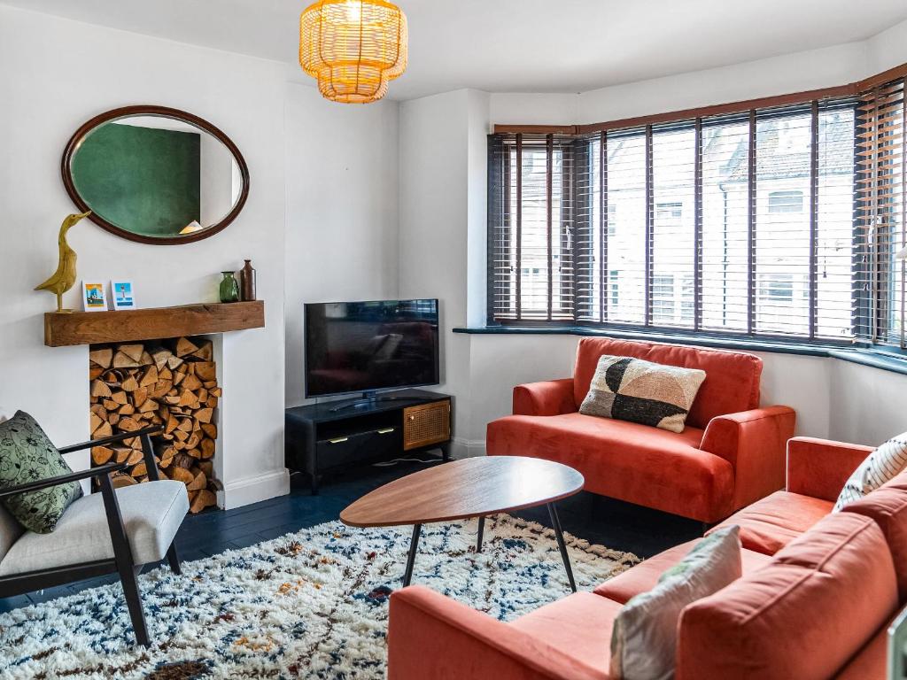 a living room with red furniture and a mirror at Eaton Beach House in Margate