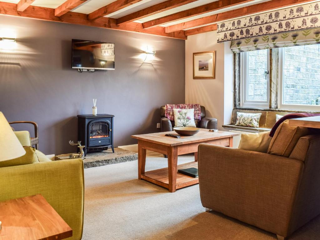 a living room with a table and a wood stove at Trough Cottage - Uk48424 in Holmfirth