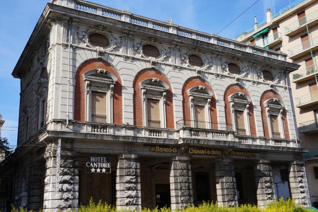 ein altes Backsteingebäude mit Fenstern auf einer Stadtstraße in der Unterkunft Hotel Cantore in Genua