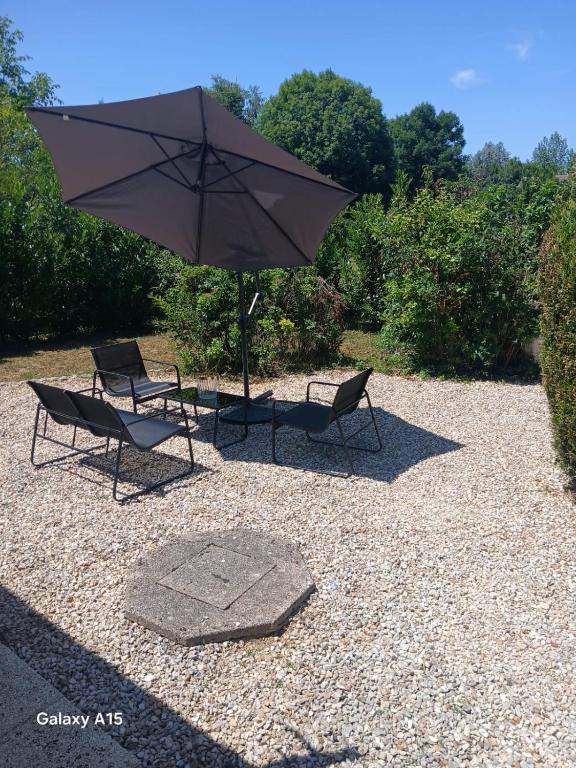 deux chaises et un parasol sur une zone de gravier dans l'établissement Jolie maison, à Gurgy