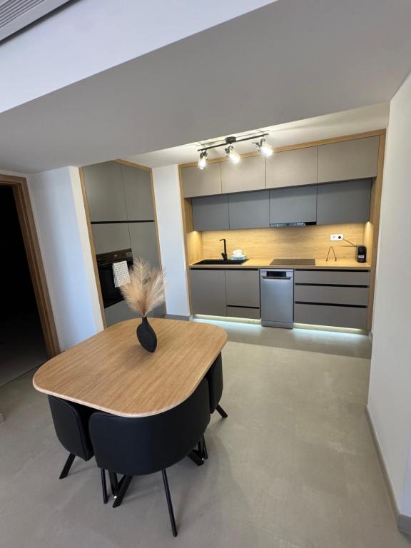 a kitchen with a wooden table and black chairs at Eden Pécs - Luxus színvonal, belvárosi kényelem in Pécs