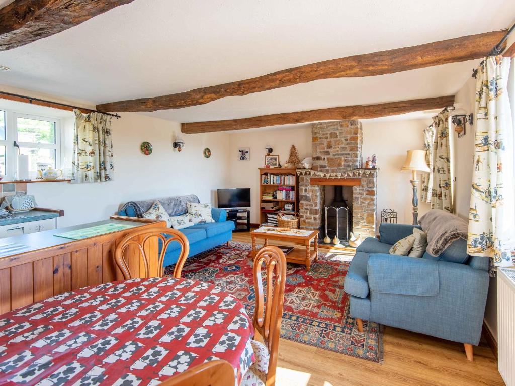 un soggiorno con un divano blu e un camino di The Old Shippen - Uk48328 a Lifton