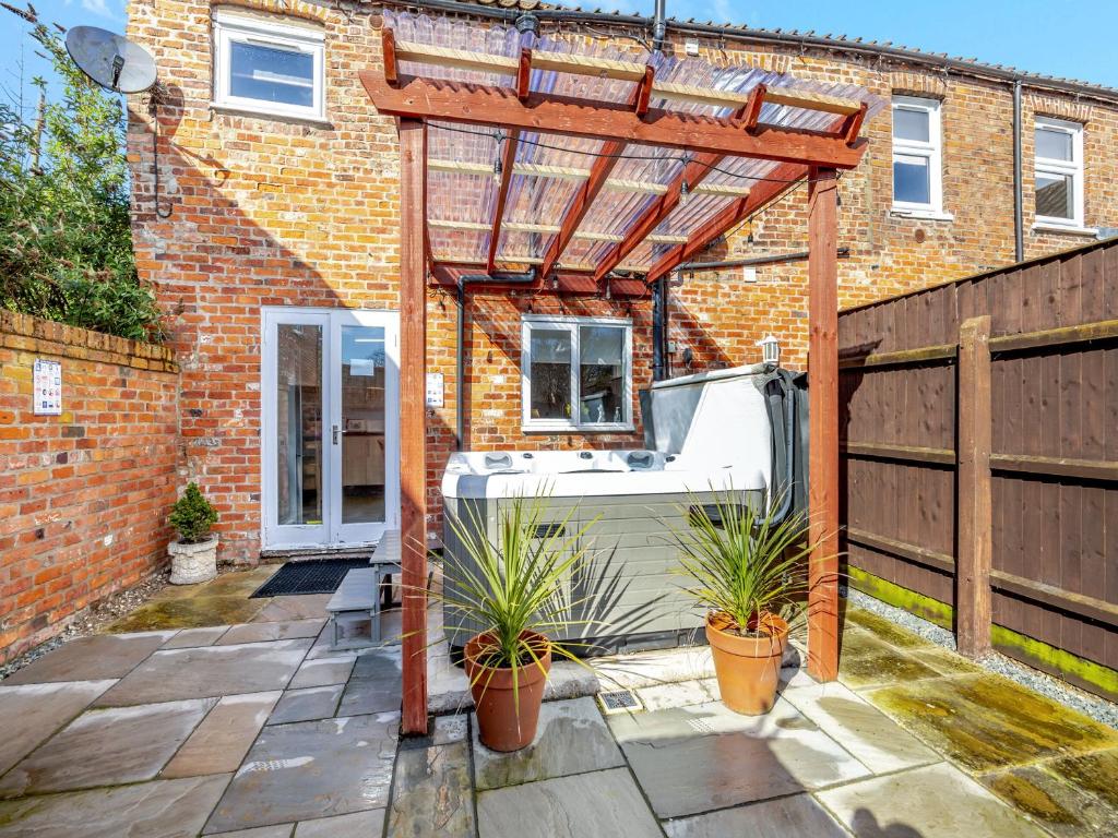 a pergola in front of a brick house at The Old Jolly in Wainfleet All Saints
