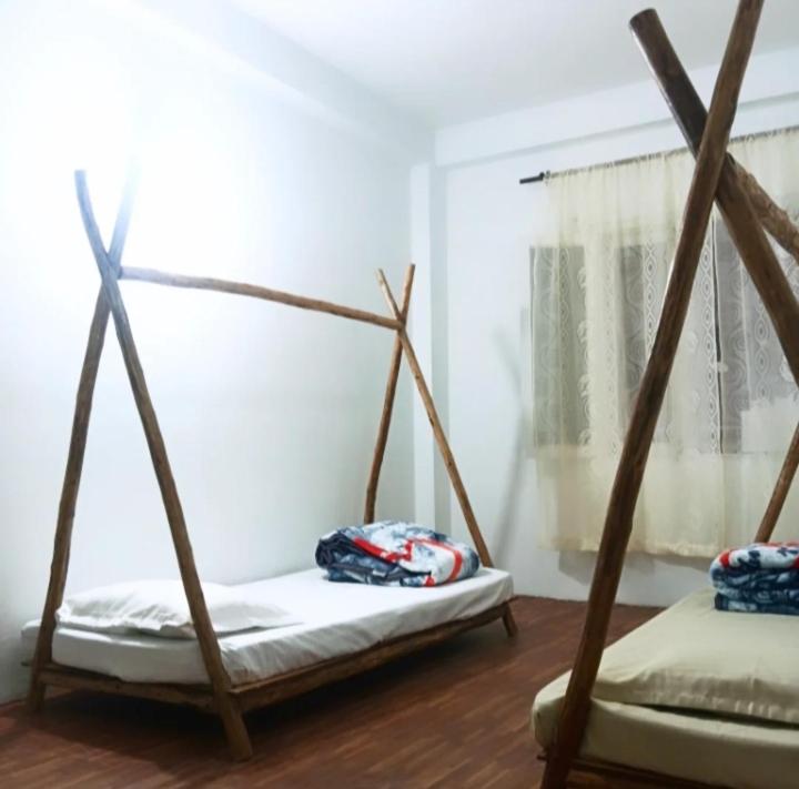 a room with two swing beds and a window at Buddies Stay Café Community in Manāli