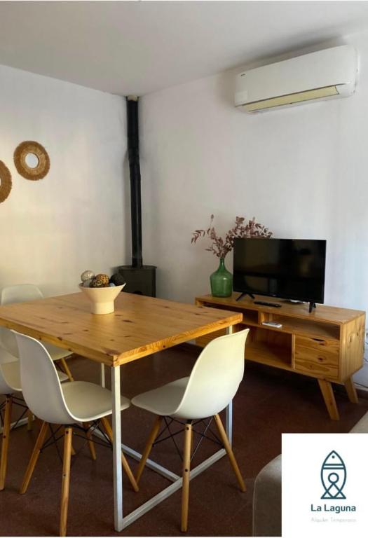 a dining room with a wooden table and chairs at La Laguna Cruz del Eje in Cruz del Eje