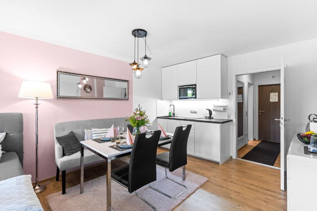 a living room and kitchen with a dining table and chairs at Ferienwohnung Harmonie mit Pool in Sankt Englmar
