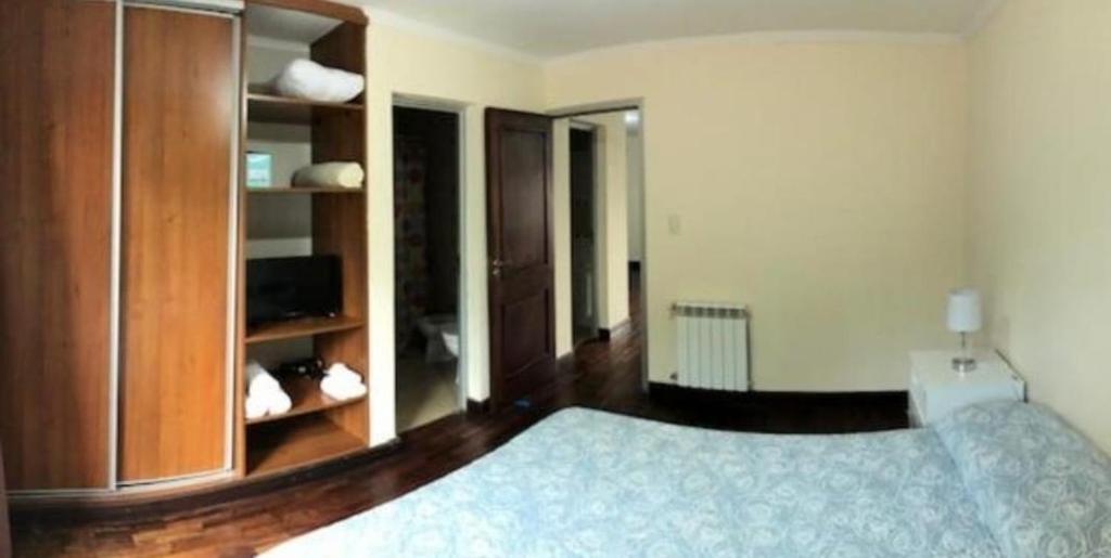 a bedroom with a bed and a wooden cabinet at Departamento Caseros in Salta