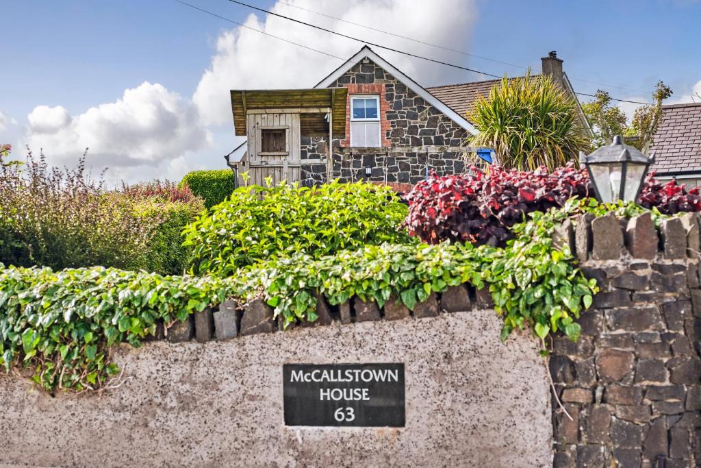 BallyclareにあるMc Callstown House Apartmentの壁に花が飾られた看板のある家