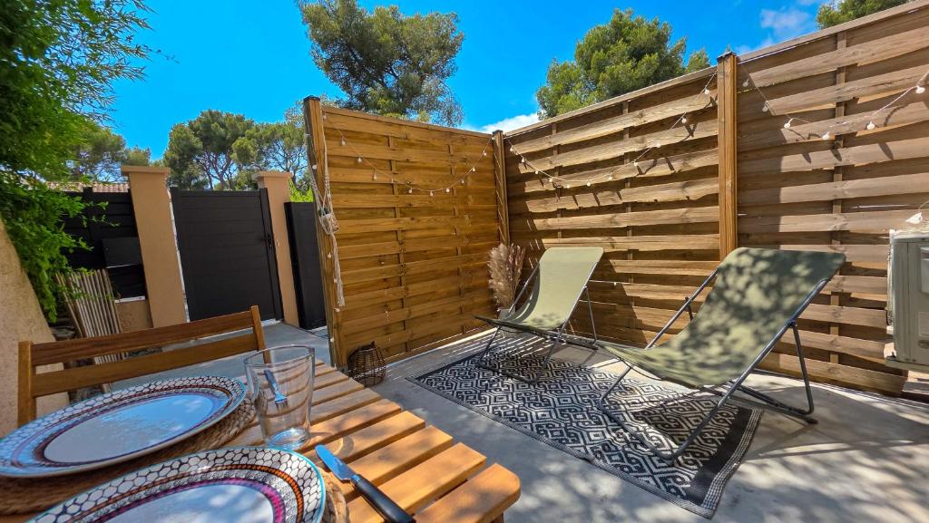 un patio avec une table et des chaises et une clôture dans l'établissement Studio avec terrasse et vrai lit 160x200cm, indépendant calme absolu dans maison de famille, à La Valette-du-Var