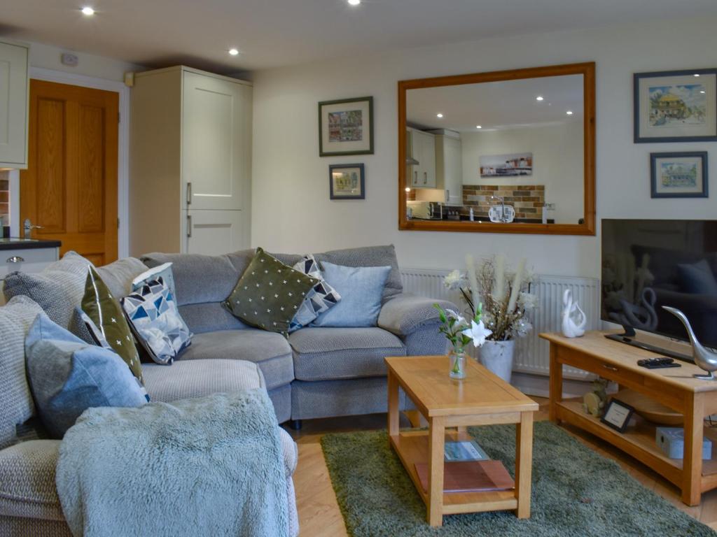 a living room with a couch and a mirror at Sailing By in Carnforth
