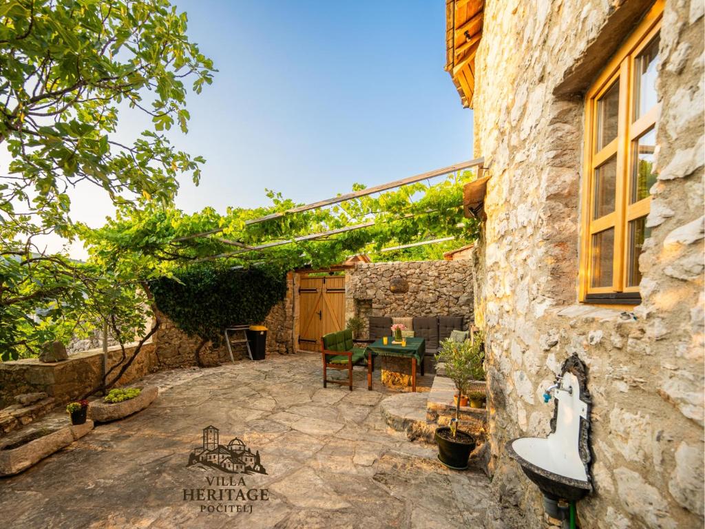un patio avec une table et un bâtiment dans l'établissement Pocitelj Heritage Stone Villa, à Počitelj