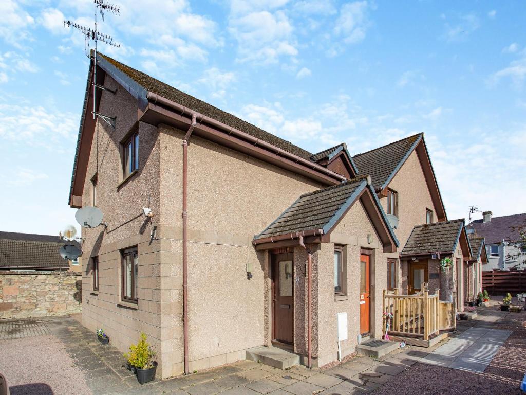 una vieja casa de ladrillo con un techo inclinado en Failte Luxury Apartment, en Inverness