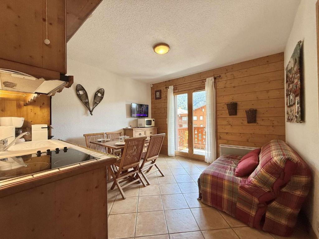 une cuisine et un salon avec une table et des chaises dans l'établissement Appartement cosy à Praz-Sur-Arly - 6 personnes - FR-1-603-124, à Praz-sur-Arly