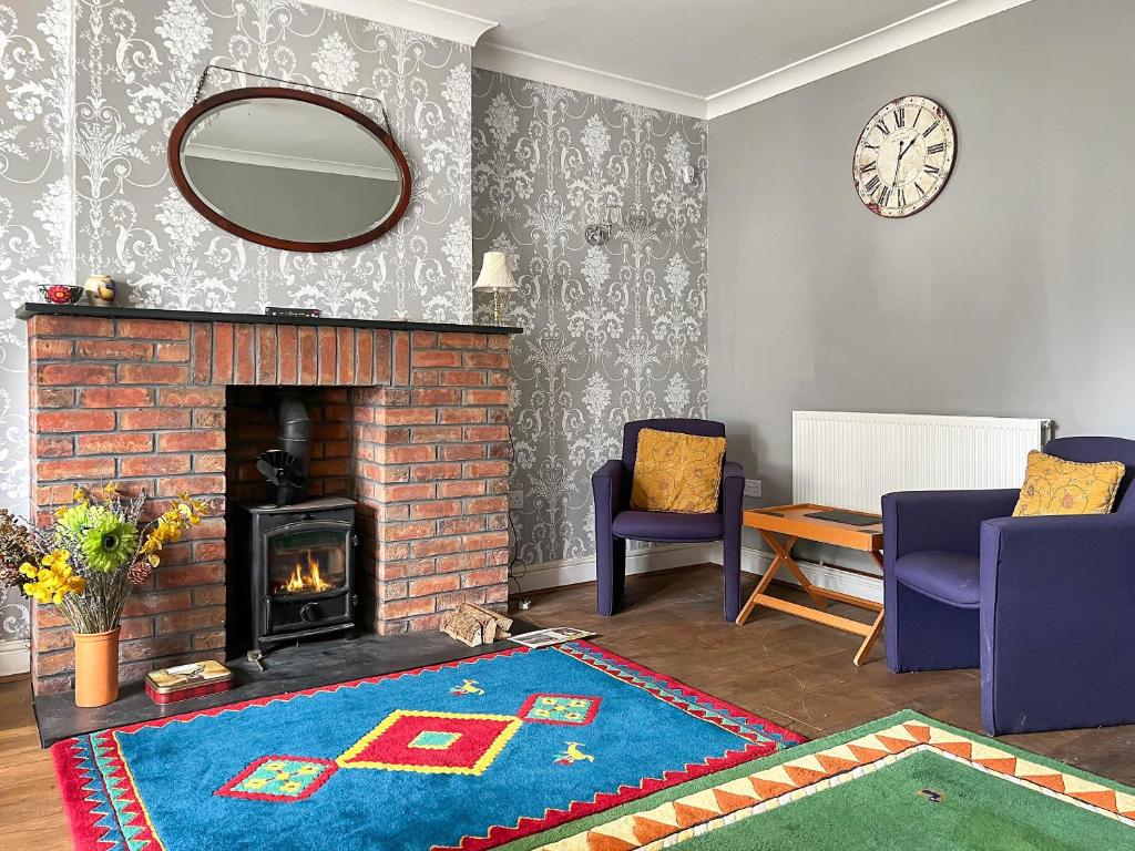 a living room with a fireplace and a mirror at Kent House in Carmarthen