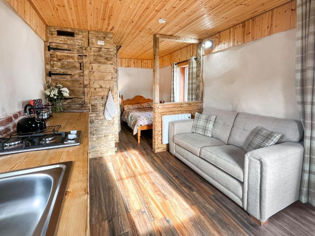 a living room with a couch and a bed at Willow Bale Cabin - Uk49074 in Ballindalloch