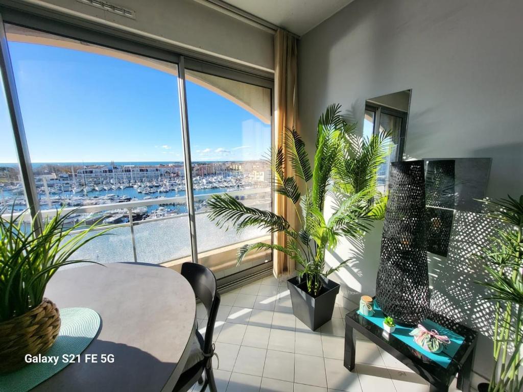 une salle à manger avec une table et une grande fenêtre dans l'établissement Studio 1 bedroom, very nice view with parking space, à Mauguio