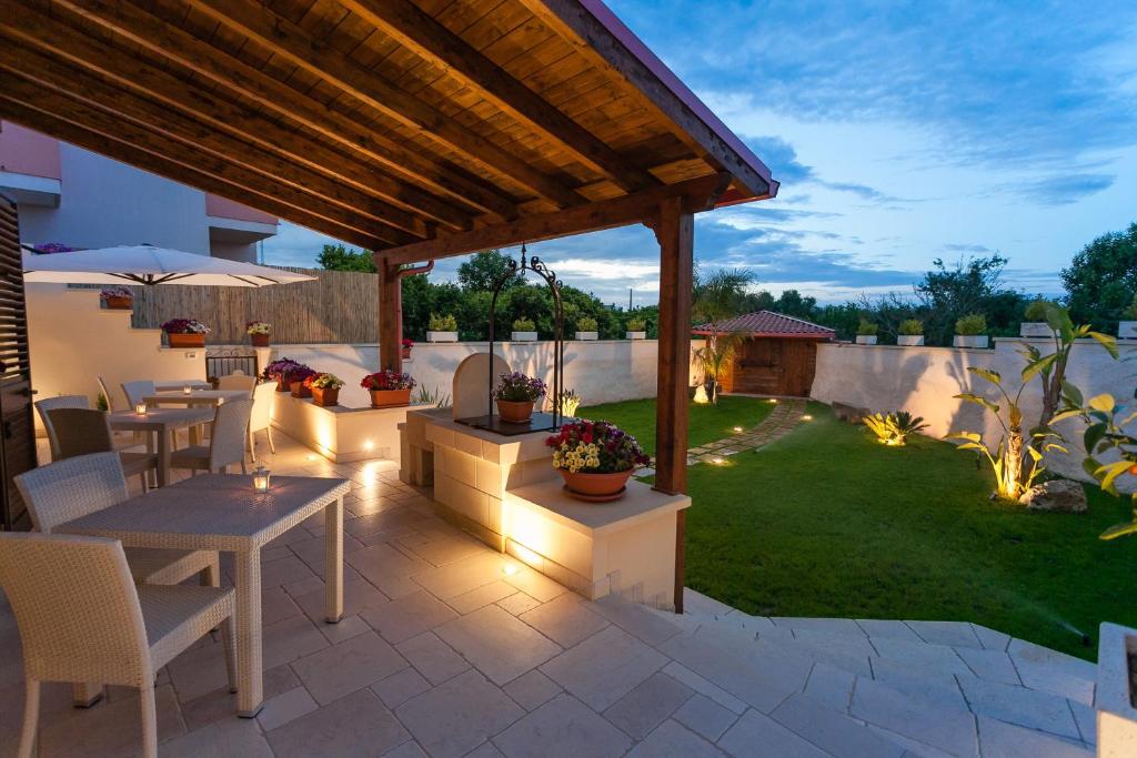 d'une terrasse avec une table et des chaises dans la cour. dans l'établissement Le Radici, à Uggiano la Chiesa