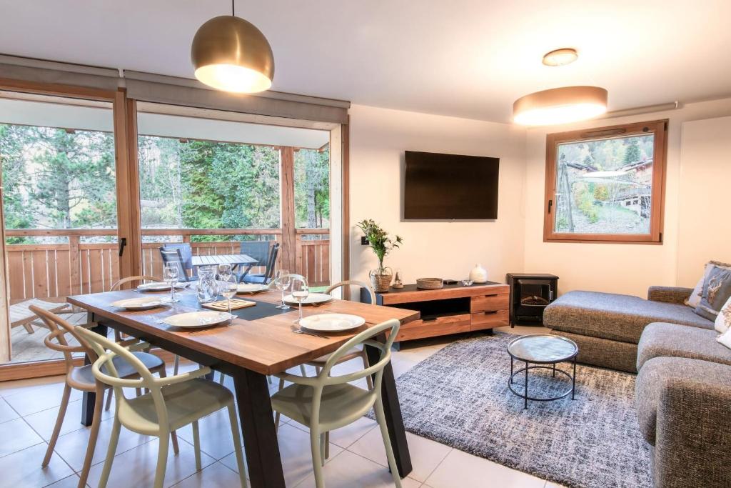 un salon avec une table et des chaises en bois dans l'établissement Appartement moderne - Les houches, aux Houches