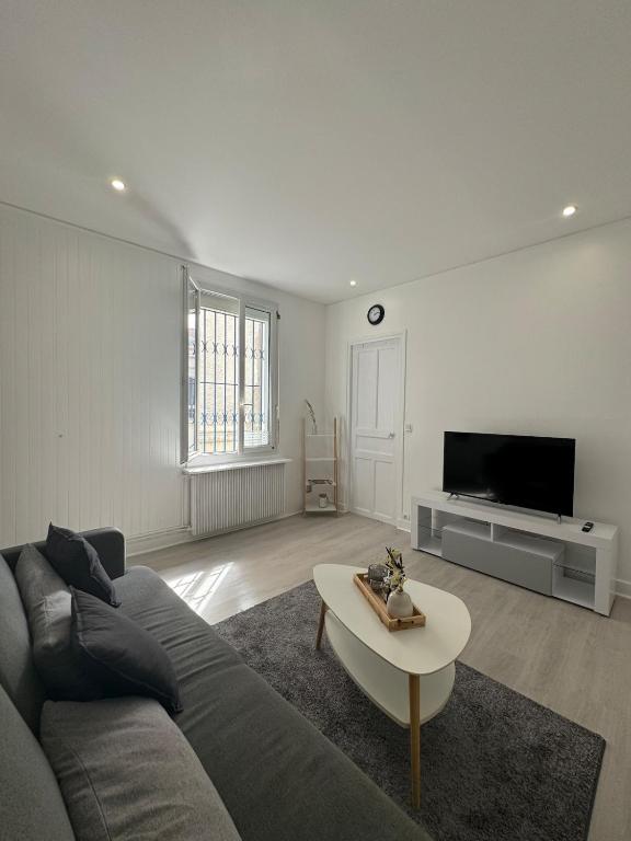 un salon avec un canapé et une table basse dans l'établissement Charmant T2, cosy et calme, à 15 minutes de Paris, à Argenteuil