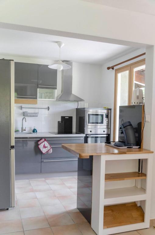 une cuisine avec des appareils en acier inoxydable et un comptoir en bois dans l'établissement Gîte en Ardèche - Coiron, à Saint-Martin-le-Supérieur