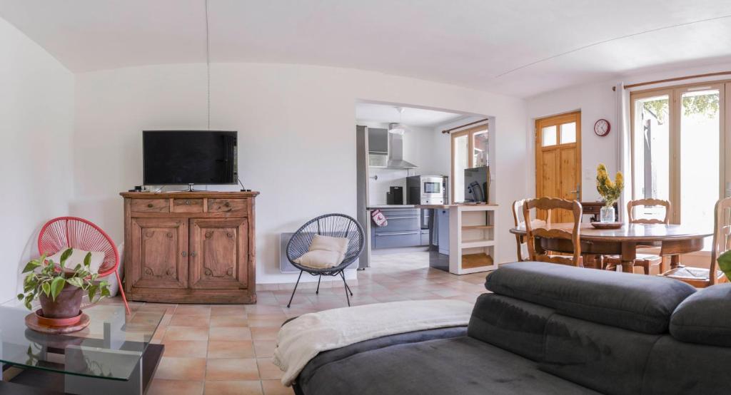 ein Wohnzimmer mit Sofa und Tisch in der Unterkunft Gîte Les Galinettes en Ardèche in Saint-Martin-le-Supérieur