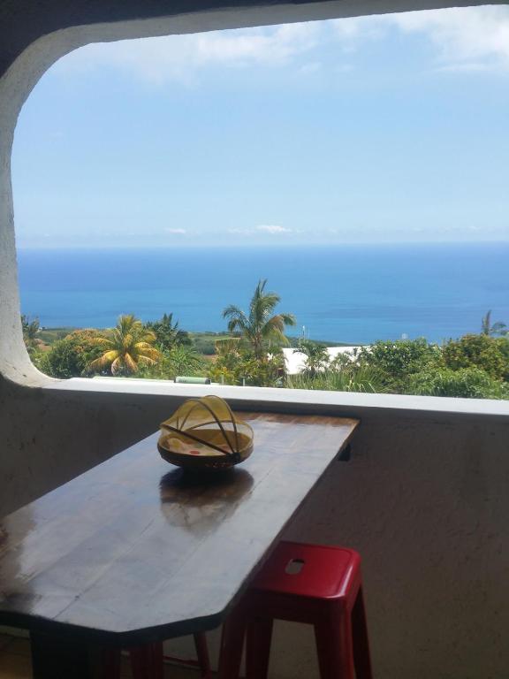 a table in a room with a view of the ocean at Ty kaz plato in Saint-Leu