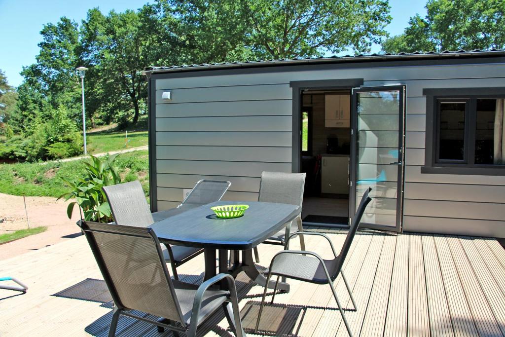 a table and chairs on a deck with a tiny house at Mobilheime am See in Lychen
