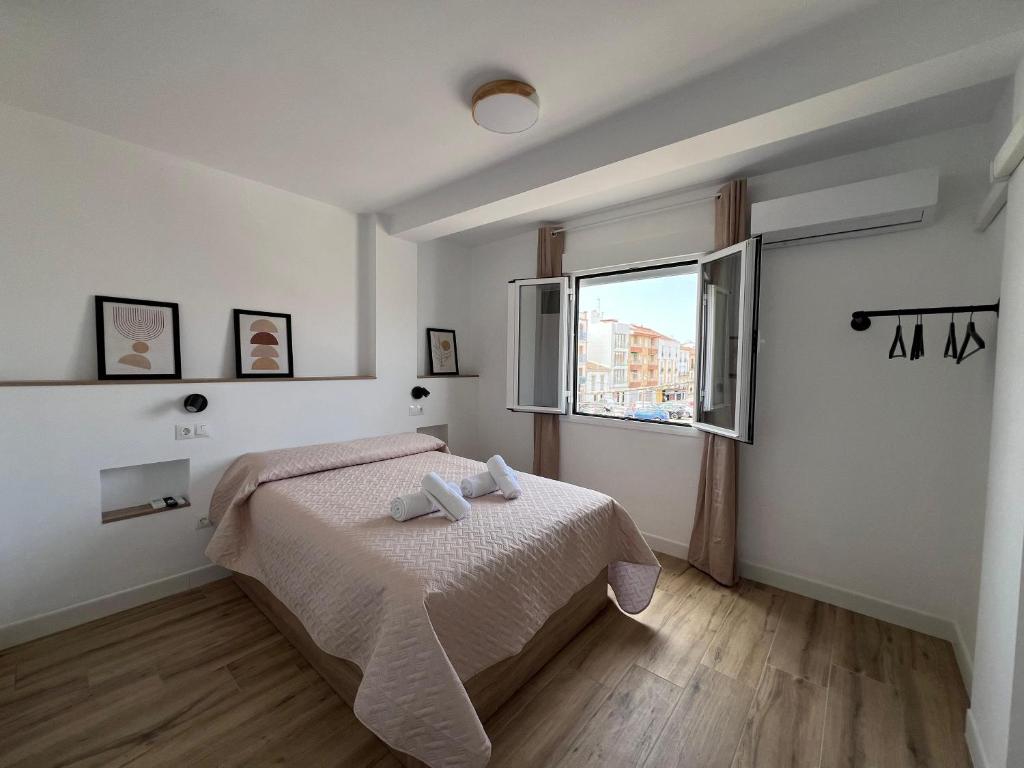 una camera da letto con un letto e una finestra di Apartamento Marina Centro a Ronda